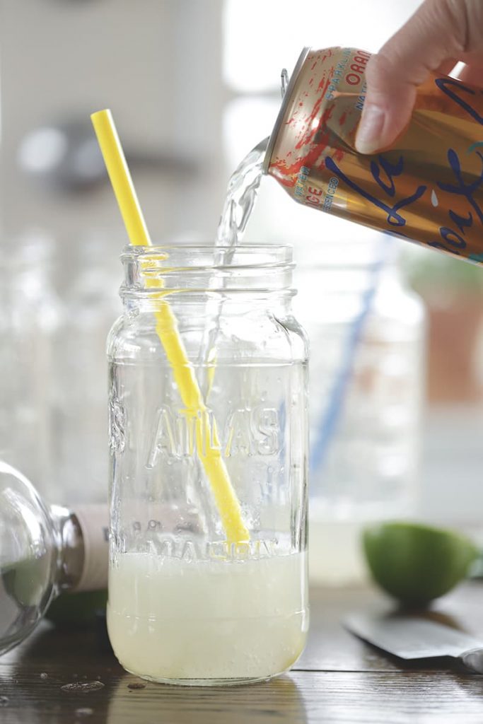 Seltzer pouring into a mason jar.