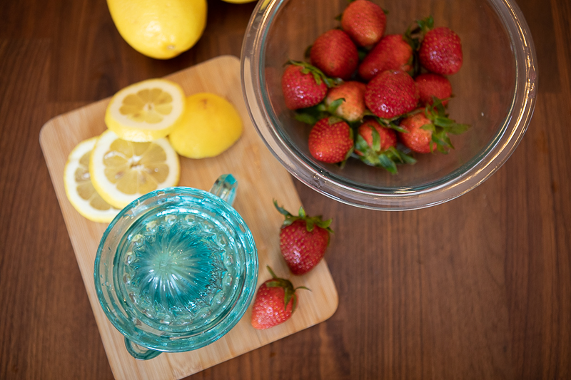 strawberries and lemons on a cutting board