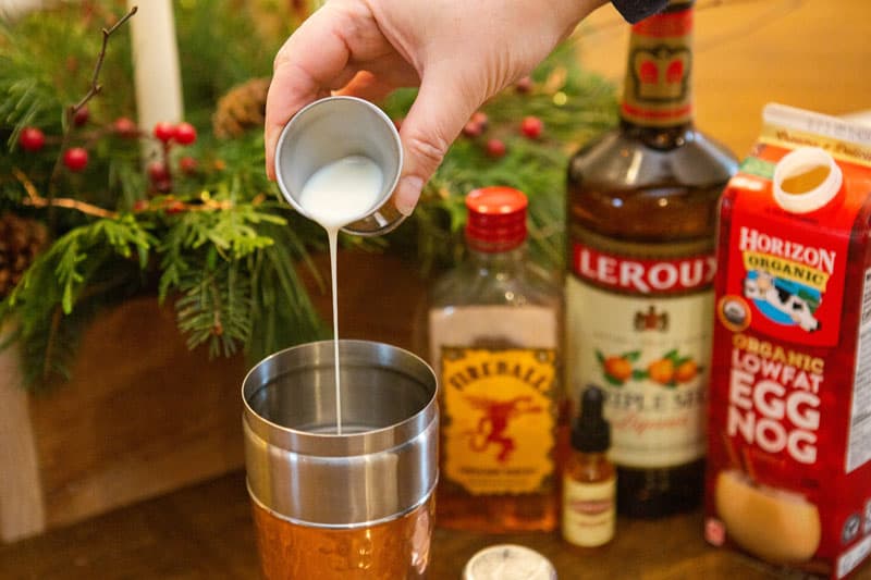 pouring eggnog into cocktail shaker