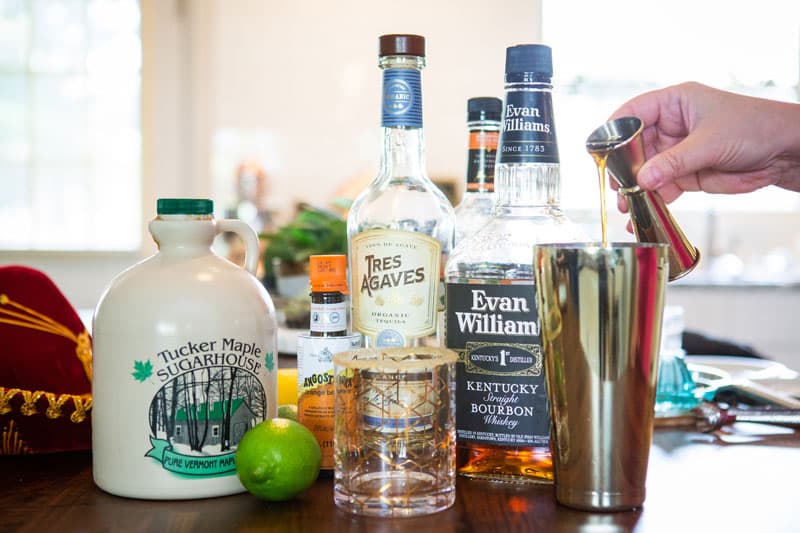 Maple syrup pouring into cocktail shaker.